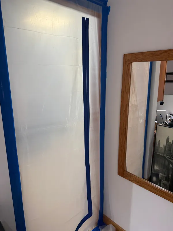 Containment sheeting taped around a bedroom doorway