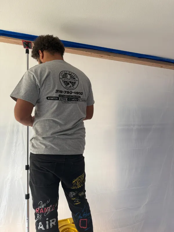 Technician hanging containment sheeting before remediation begins