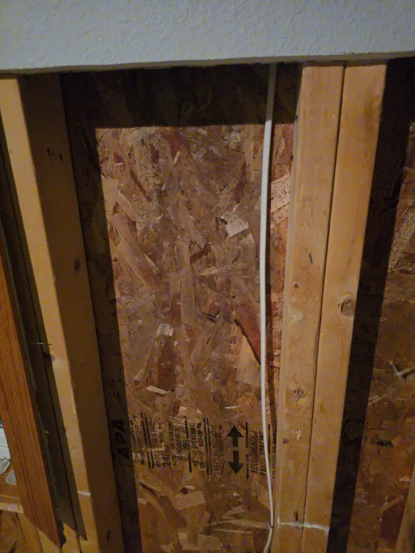 Framing and sheathing exposed in an opened wall cavity